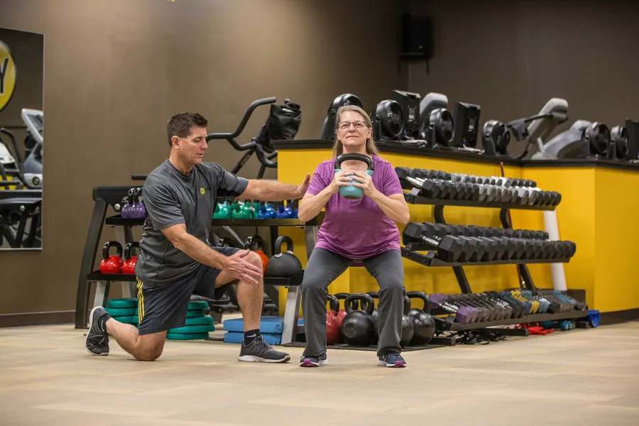 Sue and Chris during a coached kettlebell goblet squat at YES Fitness